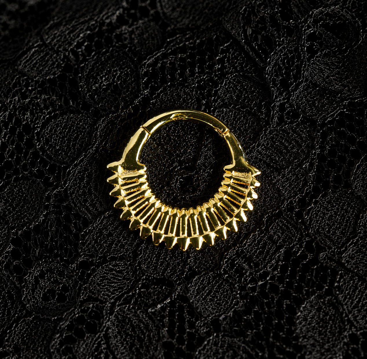 Gold hoop earring on a black textured background