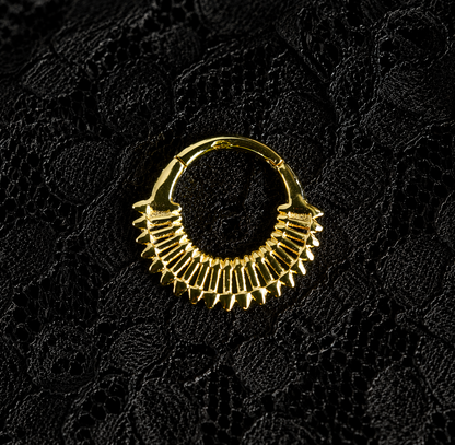 Gold hoop earring on a black textured background