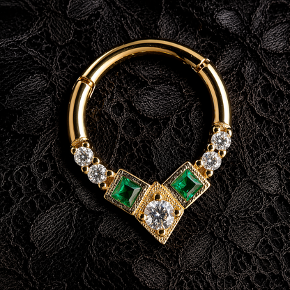 Gold hoop earring with emeralds and diamonds on a black lace background