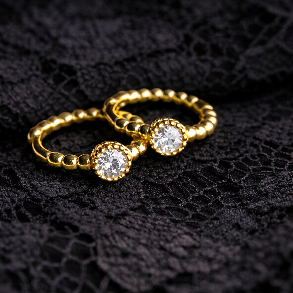 Gold ring with two clear gemstones on a black textured background