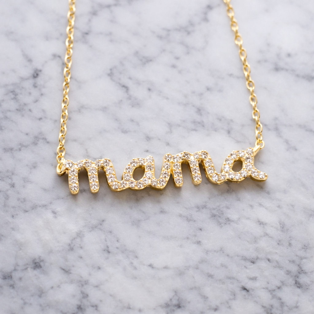 Gold 'mama' necklace on a marble background