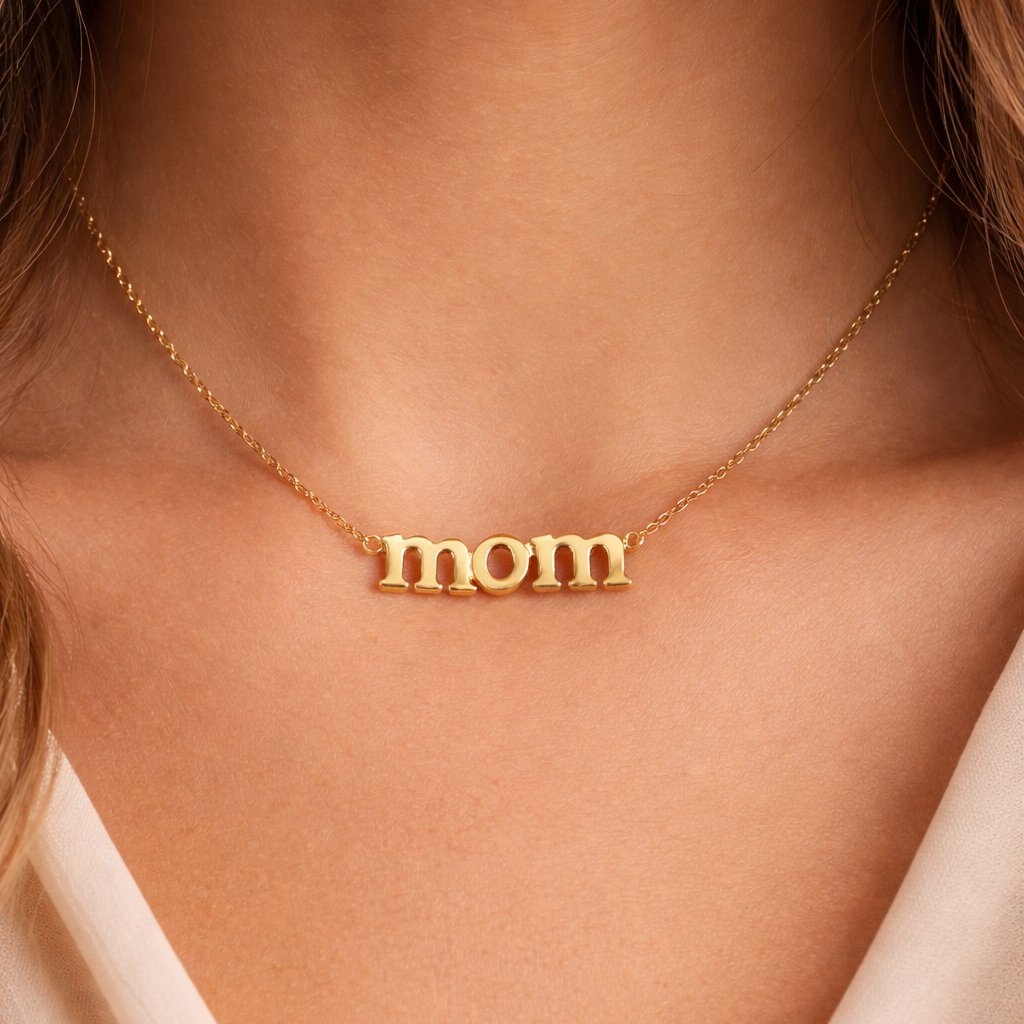 Gold 'mom' necklace on a person's neck