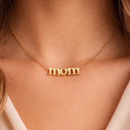 Gold 'mom' necklace on a person's neck