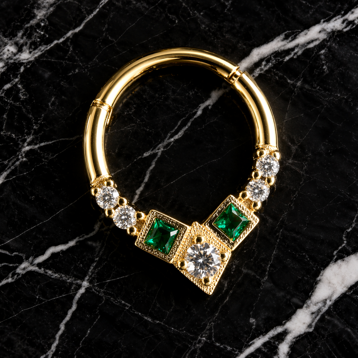 Gold nose ring with emerald and diamond accents on a black marble background