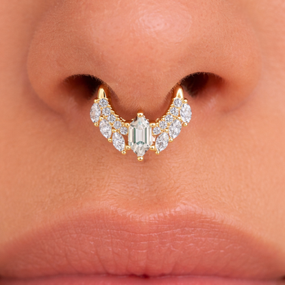 Close-up of a nose ring with gemstones and gold accents.