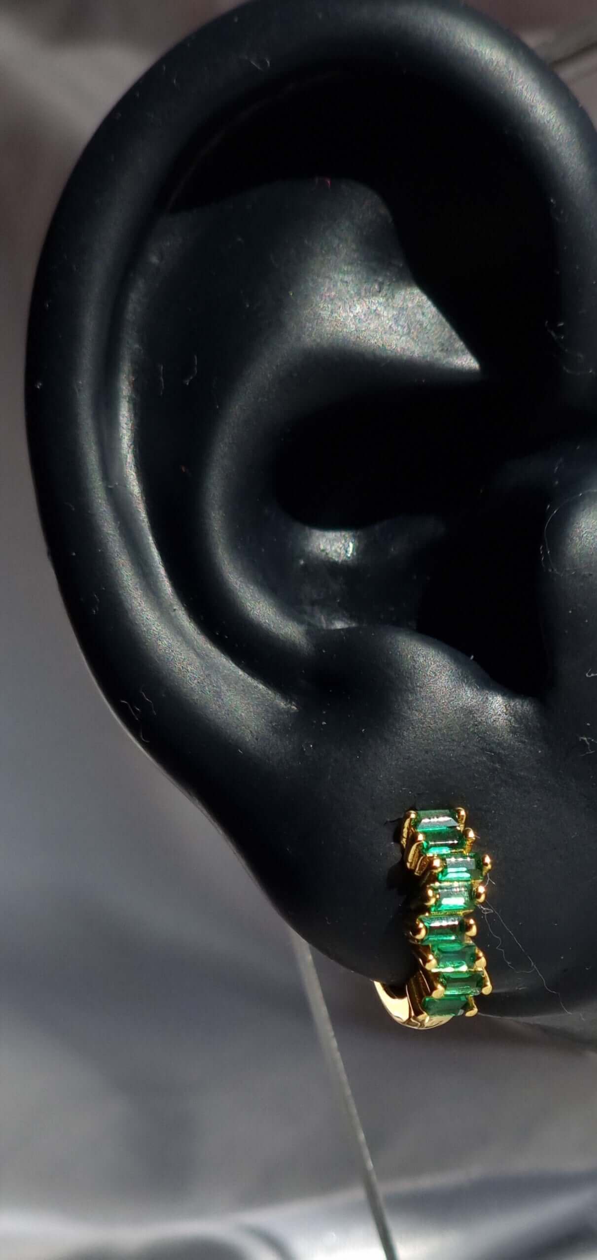 Green and Gold jewellery on ear