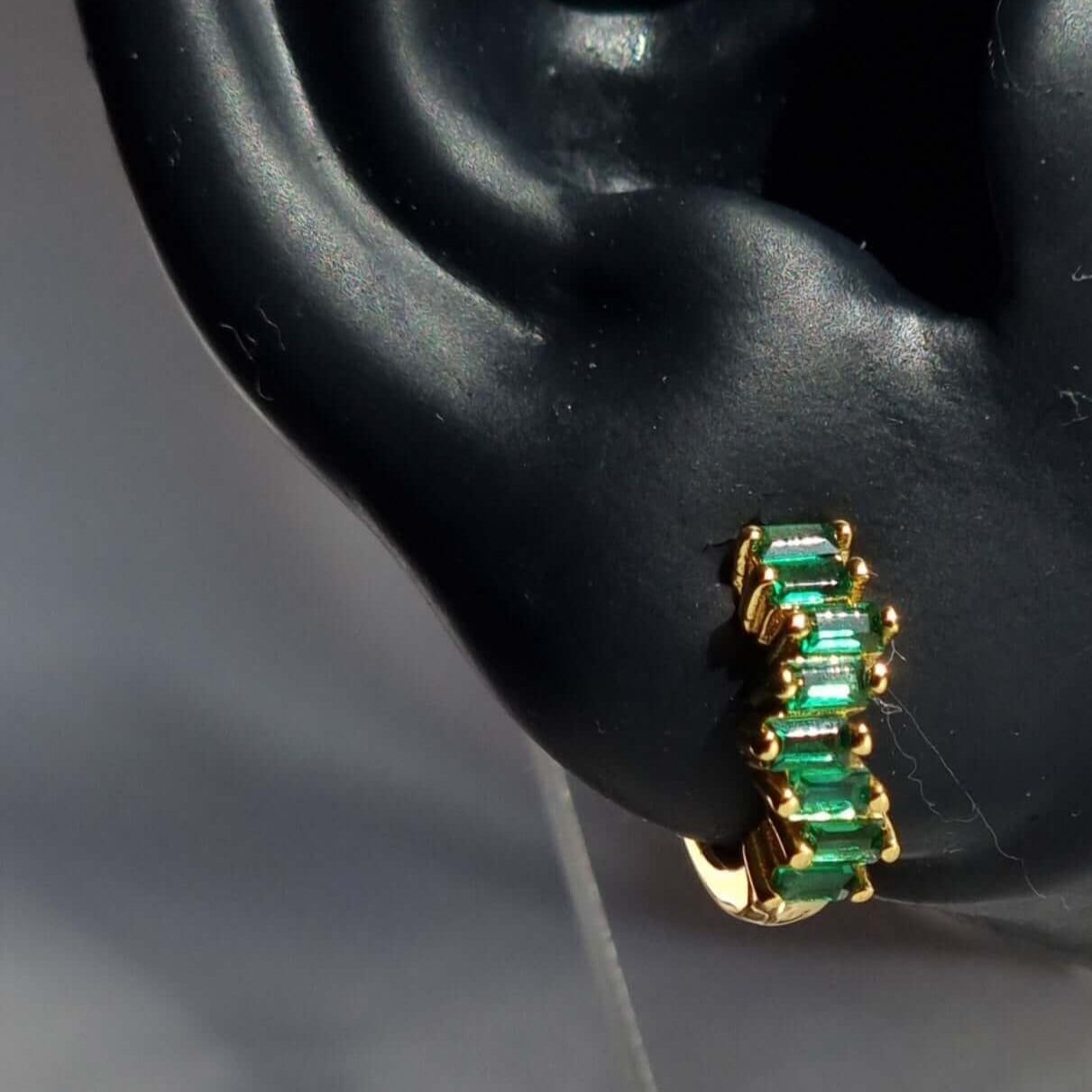 Minimalist green emerald zirconia huggie hoops in 18K gold-plated 925 sterling silver, perfect for stacking or wearing solo.
