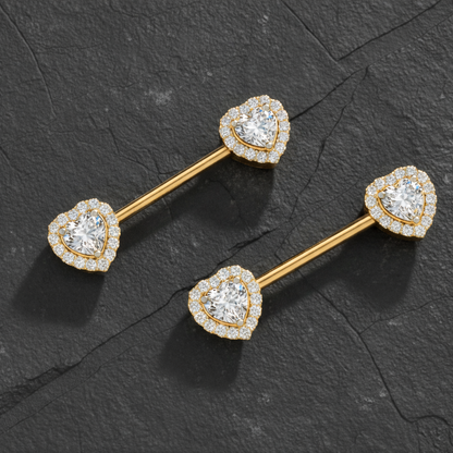 Heart-shaped diamond nipple bar piercing on a dark stone background