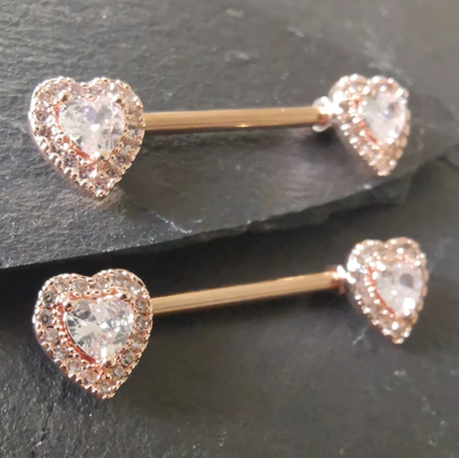Rose gold heart-shaped nipple bar piercing, crafted from 14G surgical steel 316L with cubic zirconia stones.
