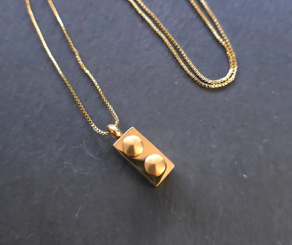 Gold Lego Brick Pendant Necklace – Stylish and unique, this 18K gold PVD plated stainless steel necklace showcases a minimalist Lego rectangle brick design. Resistant to water and sweat, making it perfect for any occasion.