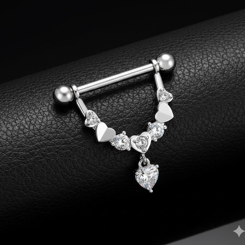 Nipple piercing jewellery with heart-shaped charms on a black leather background