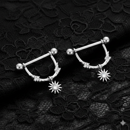 Pair of nipple piercing shields with star designs on a black lace background