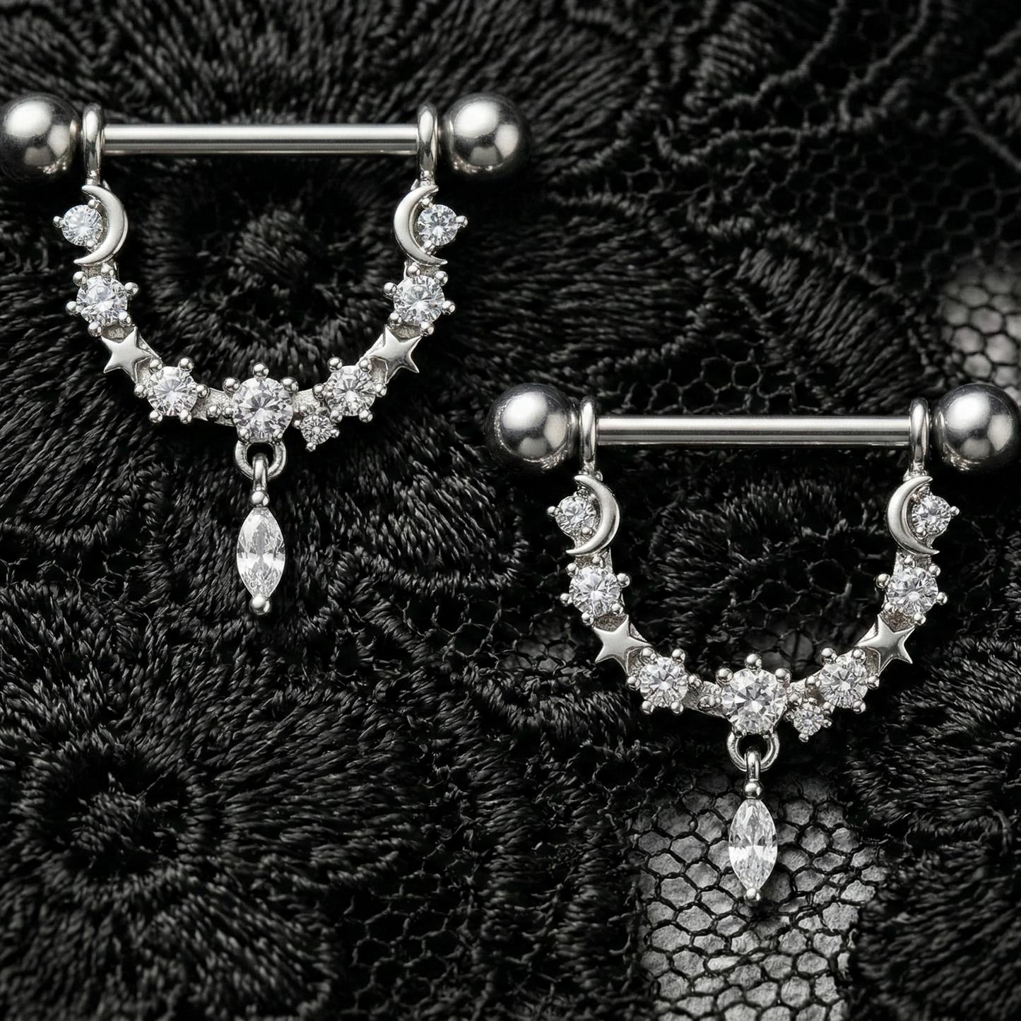 Pair of silver nipple barbels with gemstones on a black lace background