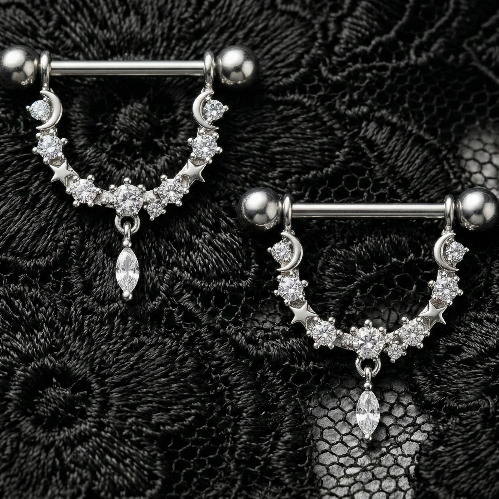 Pair of silver nipple barbels with gemstones on a black lace background