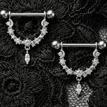 Pair of silver nipple barbels with gemstones on a black lace background