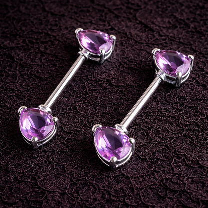 Pair of silver nipple bars earrings with purple gemstones on a dark textured background