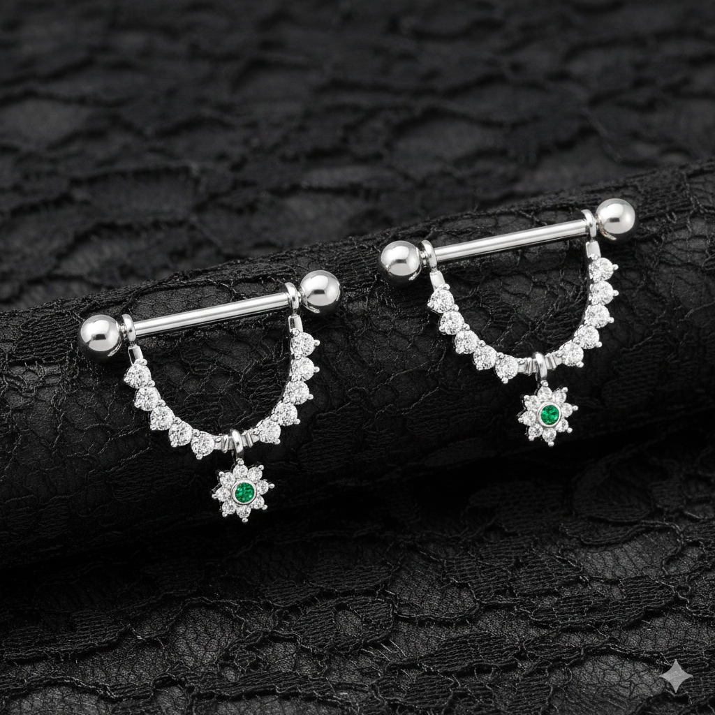 Pair of silver nipple bars with gemstones on a black lace background