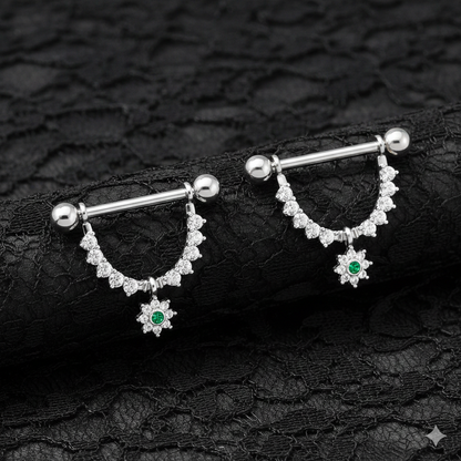 Pair of silver nipple bars with gemstones on a black lace background