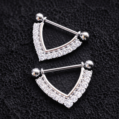 Pair of silver nipple shieldswith clear gemstones on a black background
