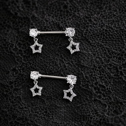 Pair of star-shaped nipple bars on a textured black surface