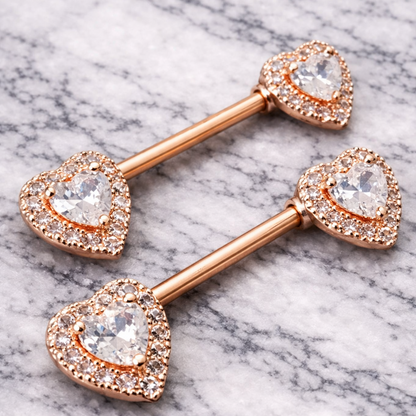 Rose gold barbell with heart-shaped ends on a marble background