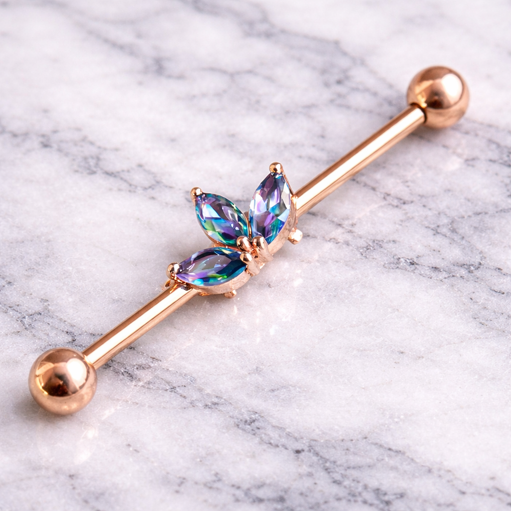 Rose gold industrial ear ring with rainbow gemstones on a marble background