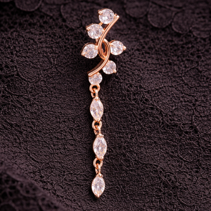 Rose gold belly button ring  with clear stones on a dark textured background