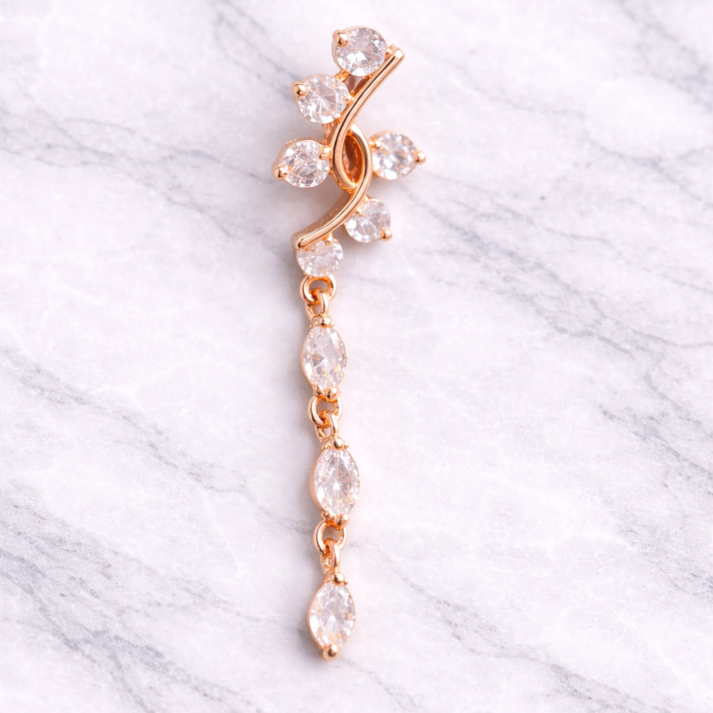 Rose gold belly ring with clear stones on a marble background