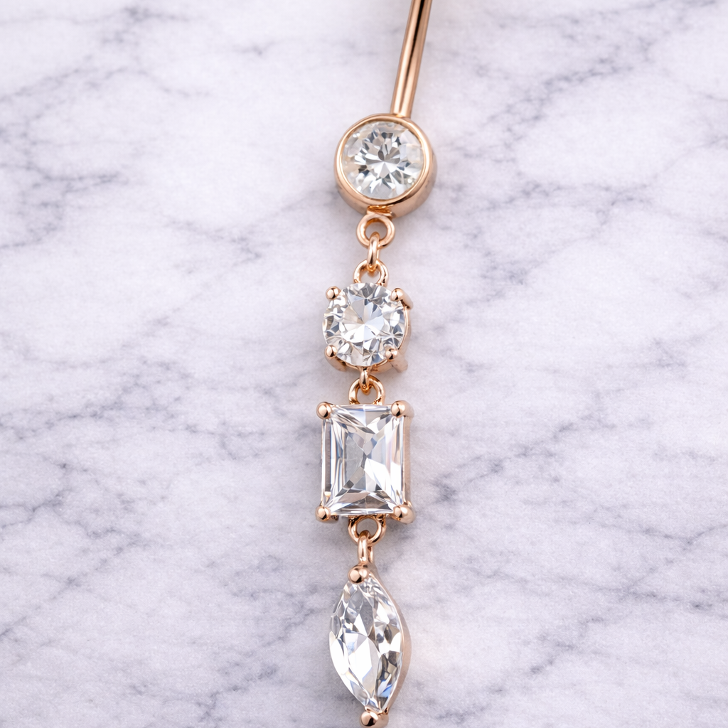 Rose gold belly button ring with clear gemstones on a marble background