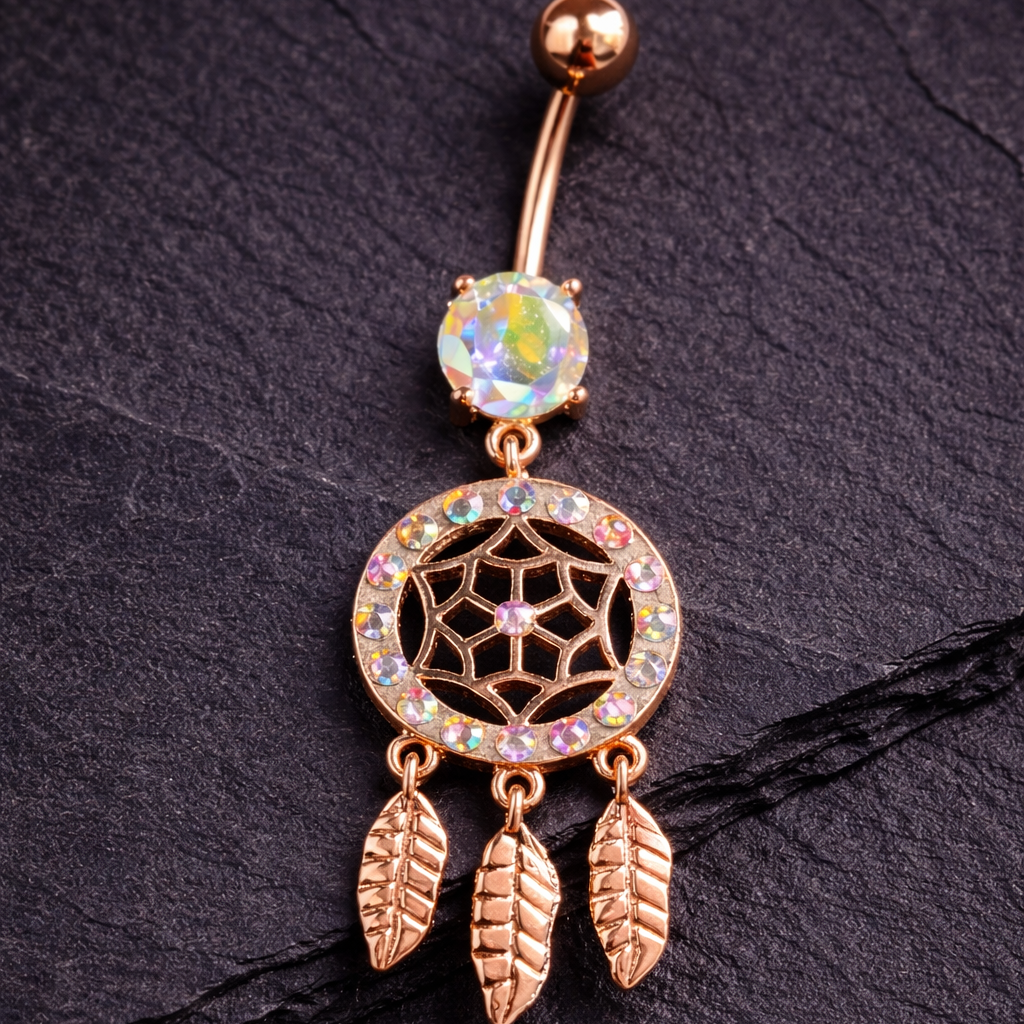 Rose gold belly button ring with gemstone and feather design on a dark background