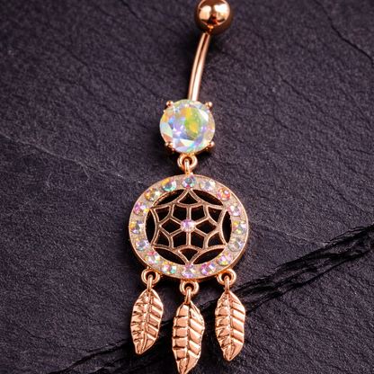 Rose gold belly button ring with gemstone and feather design on a dark background