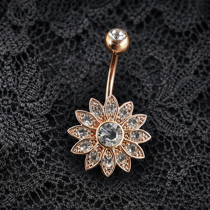 Decorative belly button ring with floral design on a black lace background