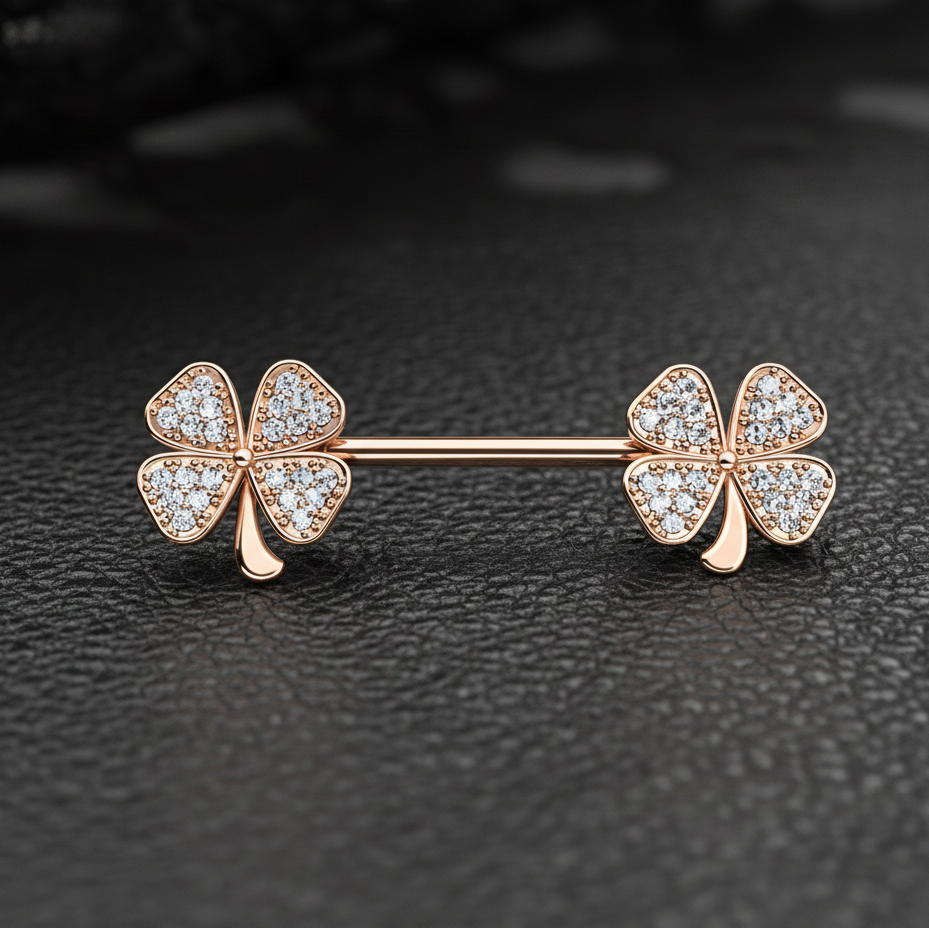 Rose gold four-leaf clover nipple barbell on a dark textured background