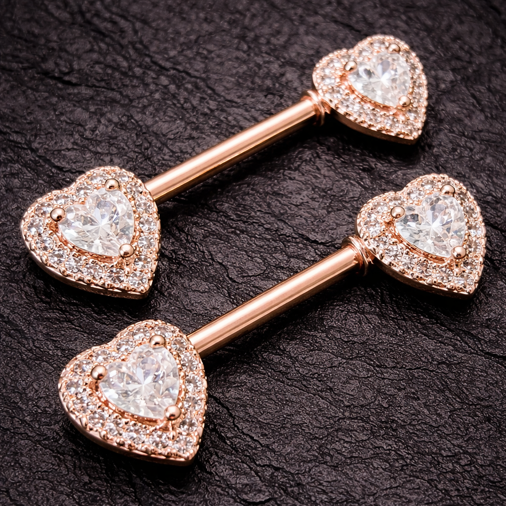 Rose gold heart-shaped nipple jewelry pieces on a dark textured background