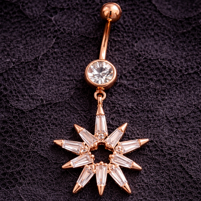 Rose gold belly button ring with star-shaped pendant on a dark textured background