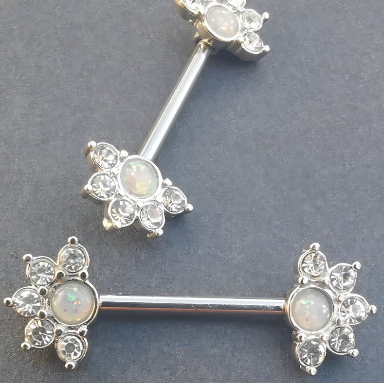 316L stainless steel mandala flower nipple bar showcasing a luminous white opal stone at its center.