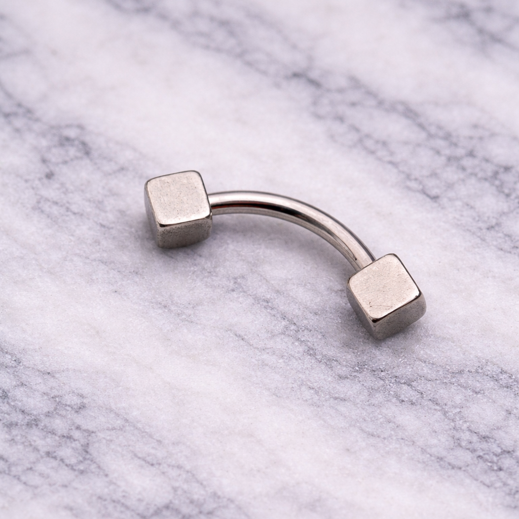 Silver Metallic eyebrow/rook barbell on a marble surface