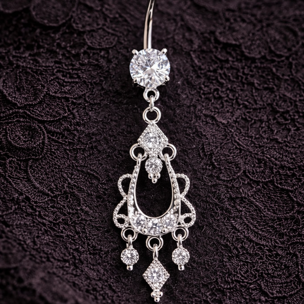 Silver belly button ring with chandelier design on a dark textured background