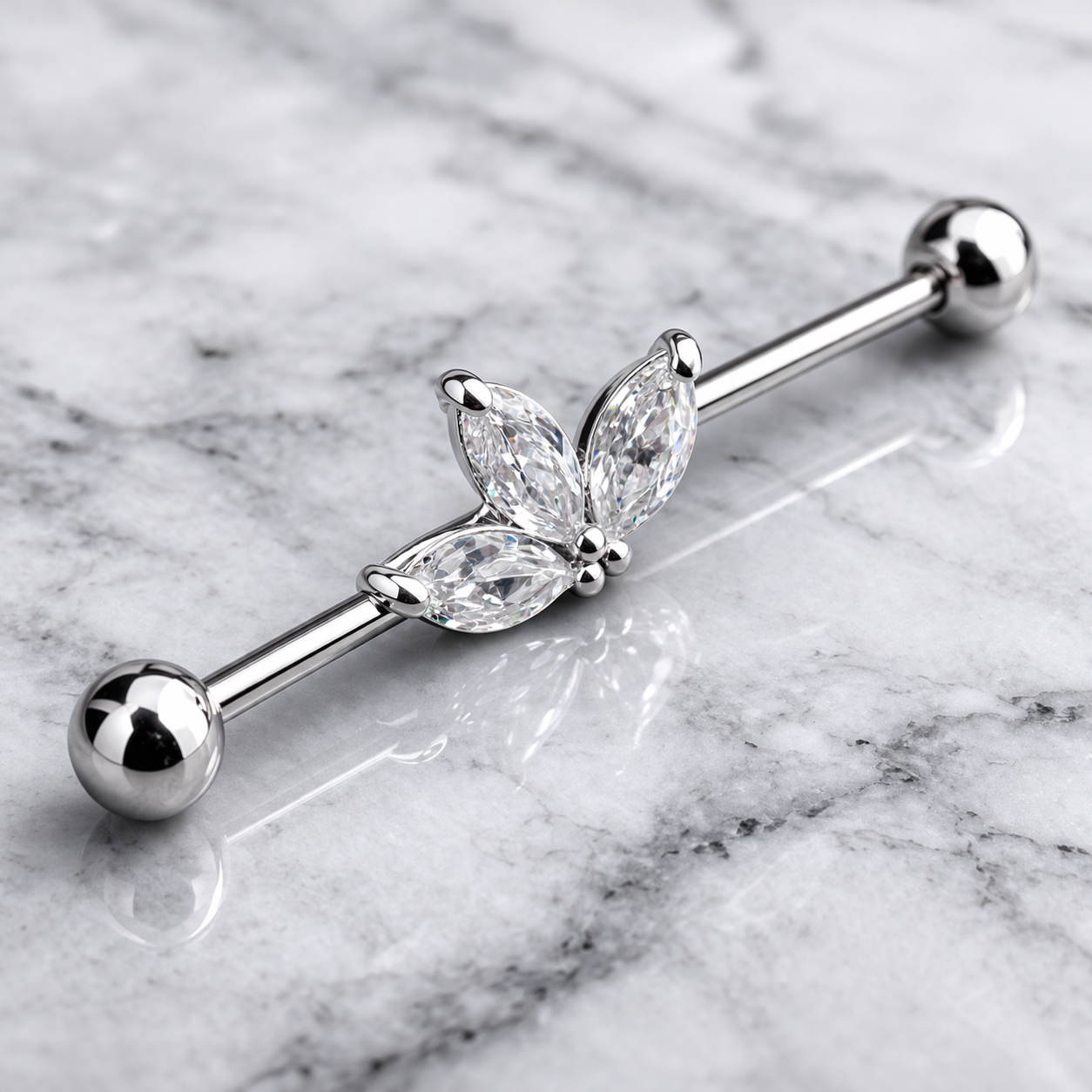 Silver industrial ear ring with leaf design on a marble background