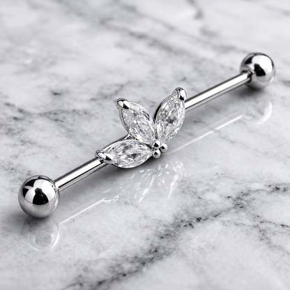 Silver industrial ear ring with leaf design on a marble background