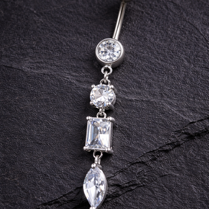 Belly button ring with clear gemstones on a black leather surface