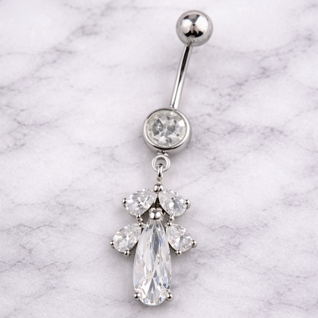 Silver belly button ring with a teardrop-shaped gem on a marble background