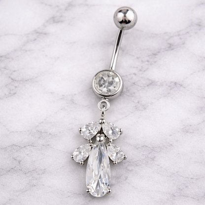 Silver belly button ring with a teardrop-shaped gem on a marble background