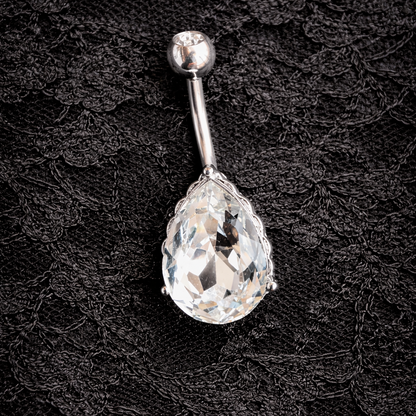 Belly button ring with teardrop crystal on a black lace background