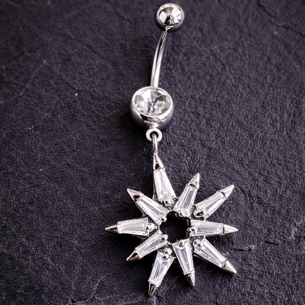 Silver star-shaped belly button ring on a dark textured background