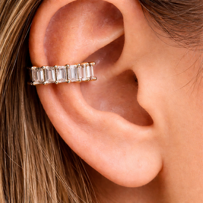 Close-up of an ear wearing a gold and diamond earring.