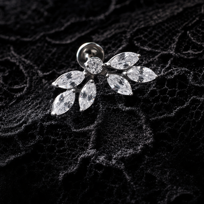 Silver earring with clear gemstones on a textured black background