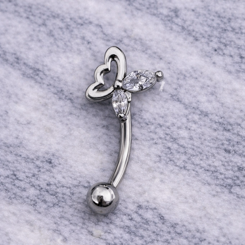Silver eyebrow/rook bar with butterfly design on a marble background