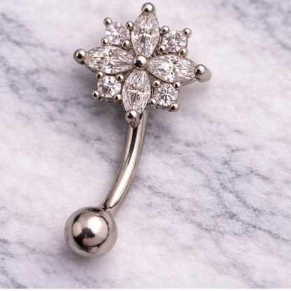 Silver eyebrow/rook bar with star-shaped design on a marble background