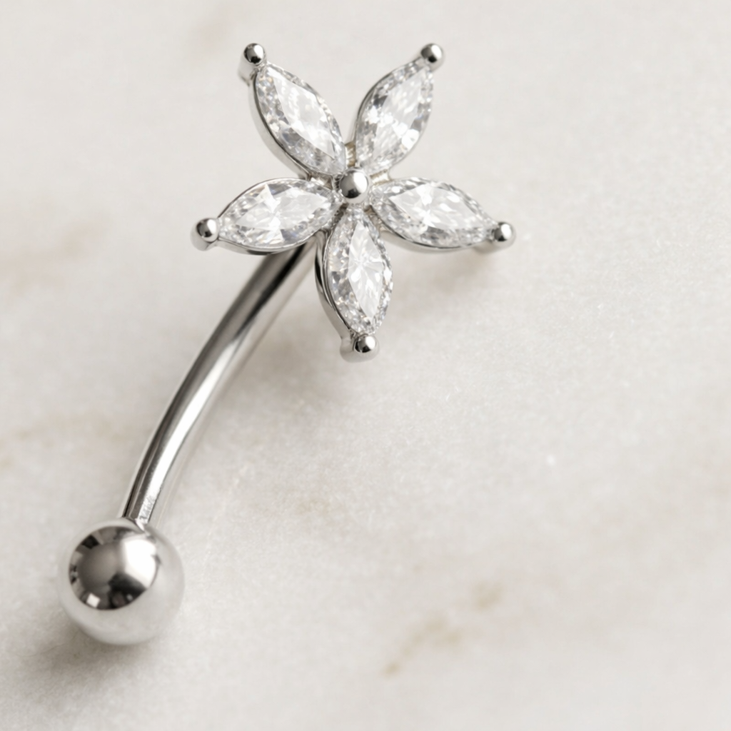 Silver eyebrow/rook bar with star clear gemstones on a light background